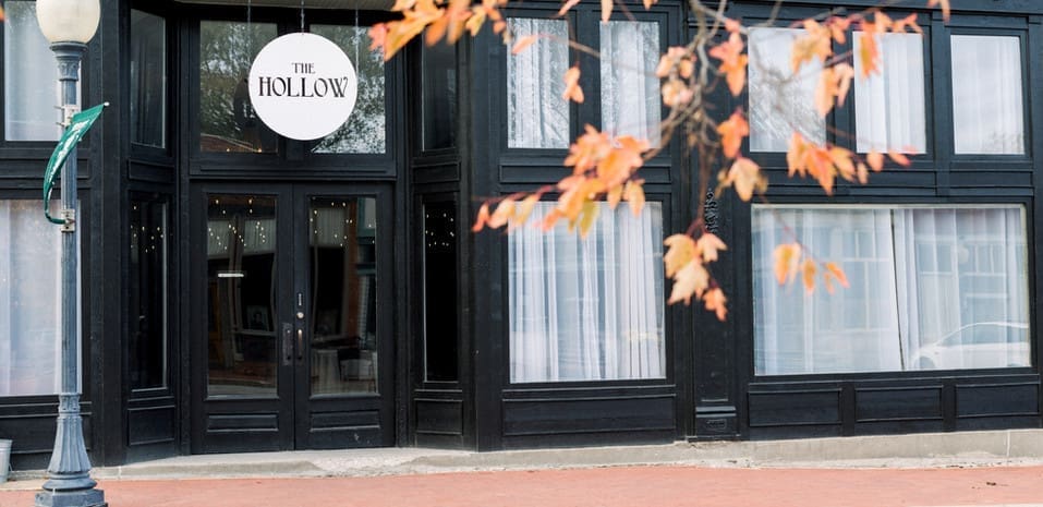 "The Hollow," a two-story brick building built in 1909. This iconic structure once housed Blackwater's first general store on the lower level, while the upper floor served as the town's social hall, hosting community events such as dances, plays, and even basketball games. Today, The Hollow has been carefully restored and now serves as Wildcliff’s indoor reception hall, featuring 14-foot ceilings and original brick walls that add a unique and rustic charm to any event.